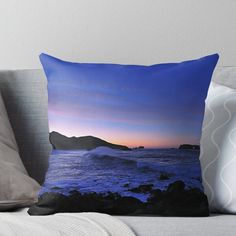 an ocean scene with waves crashing on the rocks at sunset throw pillow by designbyte