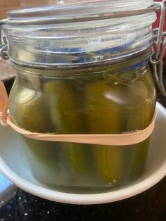 pickles in a jar with a spoon on a plate