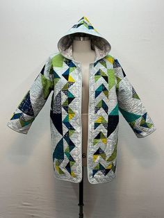 a mannequin wearing a jacket with an open hood and quilted pattern on it