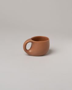 a brown cup sitting on top of a white table