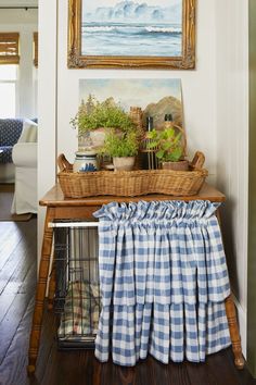 a blue and white checkered table cloth is draped over the top of a birdcage