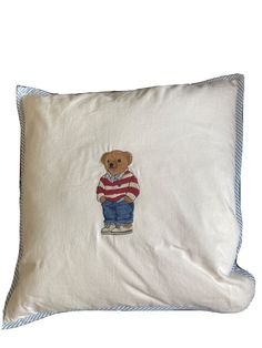 a pillow with a teddy bear embroidered on it