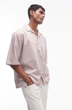 A vintage-inspired camp shirt is great for warm weather with its vertical stripes and oversized fit that looks current for today. 29" length; 46" chest (size Medium) Front button closure Notched collar Elbow-length sleeves Chest patch pocket 100% cotton Machine wash, tumble line Imported Casual Short Sleeve Shirt With Vertical Stripes, Casual Striped Camp Shirt For Vacation, Casual Striped Camp Shirt For Spring, Summer Collared Shirt With Vertical Stripes, Relaxed Fit Vertical Stripes Top For Vacation, Casual Tops With Striped Collar For Vacation, Vertical Stripes Tops With Relaxed Fit For Vacation, Casual Top With Striped Collar For Vacation, Casual Vacation Top With Striped Collar