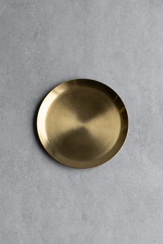 a gold plate sitting on top of a gray floor next to a white countertop