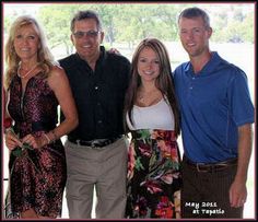 a group of people standing next to each other in front of a window with trees