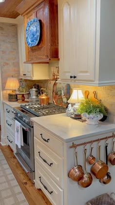 a kitchen with an oven, stove and pots hanging on the wall next to it