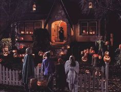 a group of people standing in front of a house decorated for halloween