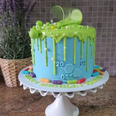 a blue cake with green icing sitting on top of a table