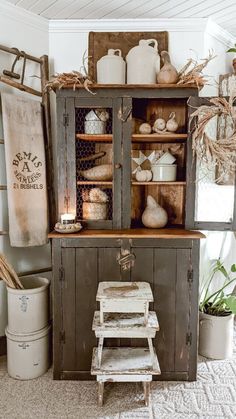 an old wooden cabinet sitting in the middle of a room with other items on top of it