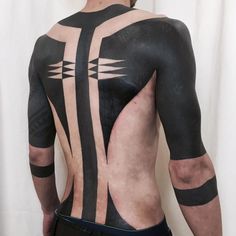 the back of a man's body covered in black and white paint with arrows on it