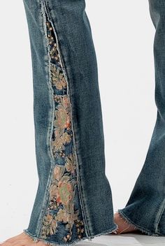 a pair of jeans with flowers on the side and an open pocket at the bottom