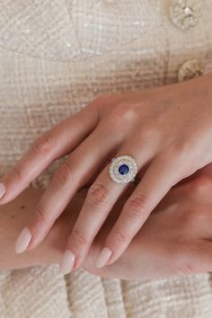 a woman's hand with a diamond and blue sapphire ring on her left wrist