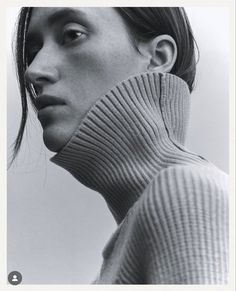 a black and white photo of a woman wearing a turtle neck sweater