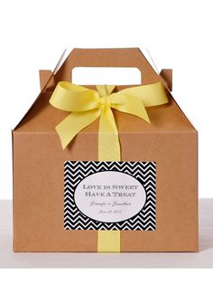 a brown box with a yellow bow and label that says love is sweet have a treat