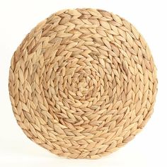 a round woven basket sitting on top of a white surface