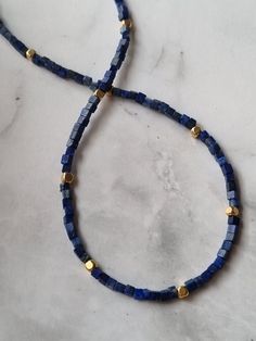 The dainty Lapis Lazuli necklace features 24k gold filled beads and is designed as a genuine natural Lapis Lazuli choker, making it an exquisite gemstone necklace perfect for those born under the Sagittarius zodiac sign, as it incorporates their birthstone. You will receive 1 necklace. 👀Discover Similar Dainty Jewelries https://www.etsy.com/shop/demetergemart/?etsrc=sdt§ion_id=44637022 ✨MATERIALS The gemstones are Lapis lazuli. The cube beads are 24k gold filled. The lobster claw clasp, extensi Adjustable Rondelle Beaded Necklaces As Gifts, Gift Jewelry With Natural Stones And Heishi Beads, Gift Lapis Lazuli Beaded Necklaces With Round Beads, Gift Lapis Lazuli Beaded Necklace With Round Beads, Lapis Lazuli Beaded Necklaces As Gift, Heishi Beads Necklace With Natural Stones For Gifting, Gift Heishi Beaded Necklace With Natural Stones, Blue Beaded Rondelle Necklaces, Heishi Spacer Beads For Jewelry Making