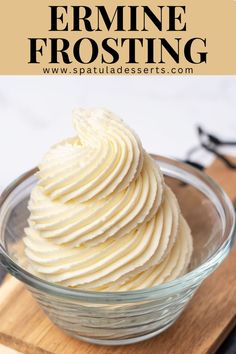 a bowl filled with white frosting on top of a wooden cutting board