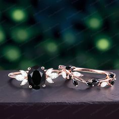 two rings with black and white stones on top of each other in front of a blurry background