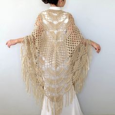 a woman wearing a crochet shawl and white dress