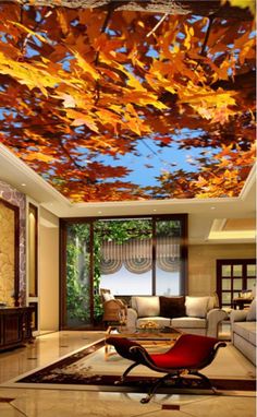 a living room filled with furniture and a ceiling covered in autumn colored leaves on the ceiling