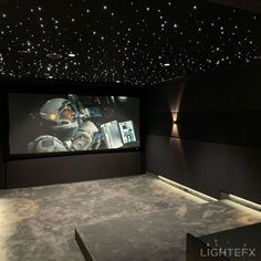 an empty room with a projector screen in the center and stars on the ceiling