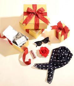 the gift box is decorated with red and white polka dots, ribbon, eyeglasses, and lipstick