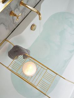 a bathroom with a sink, toilet and gold faucet in the shower area