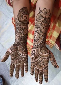 two hands with henna tattoos on them