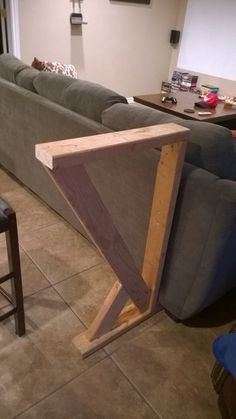 a living room filled with furniture and a large triangle shaped piece of wood on the floor