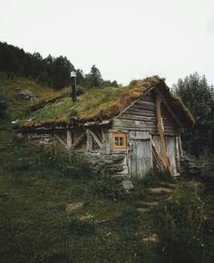 an old wooden cabin with grass roof