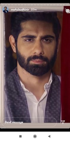 a man with a beard is looking at the camera while wearing a white shirt and vest