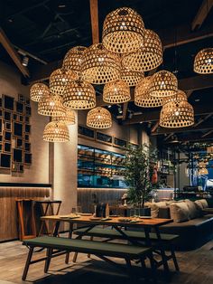 a restaurant with wooden tables and lights hanging from the ceiling over it's seating area