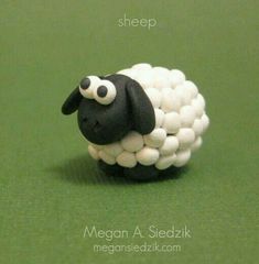 a sheep made out of marshmallows sitting on top of a green surface