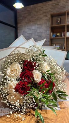 a bouquet of red and white roses on a table