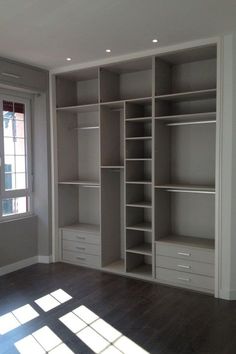 an empty room with some shelves and drawers