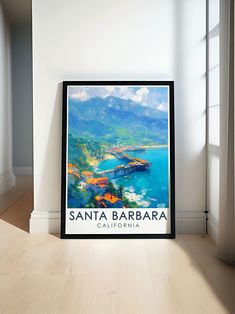 a framed poster on the floor in front of a window with a view of santa barbara, california