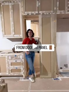 a woman standing in the middle of a room that is being built with unfinished cabinets