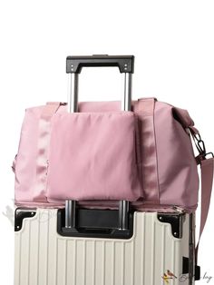 a pink bag sitting on top of a piece of luggage with straps attached to it