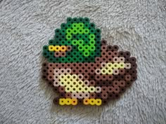 a piece of art made out of perler beads with an image of a plant on it