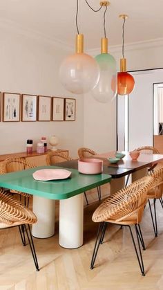 a dining room table with chairs and hanging lights