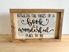 a wooden frame with the words between the pages of a book is a wonderful place to be