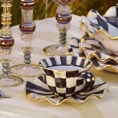 a table topped with plates and cups filled with wineglasses on top of a white table cloth