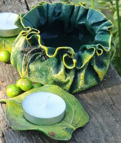 a candle sits on a wooden table next to a green potted plant and two candles