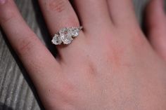 a person's hand with a diamond ring on it