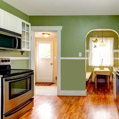 a kitchen with green walls and wood floors