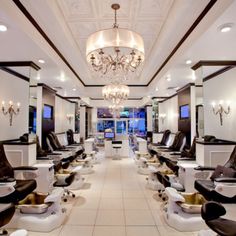 a large room filled with lots of white chairs and chandelier hanging from the ceiling