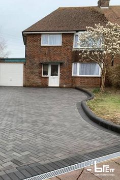 a brick driveway in front of a house