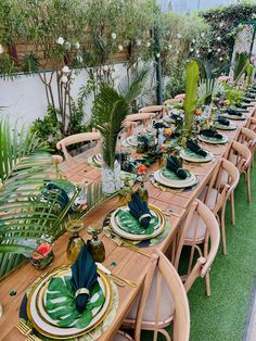 a long table set with plates and place settings for an outdoor dinner party or gathering