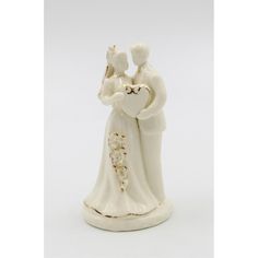 a ceramic figurine of a bride and groom holding each other's hands