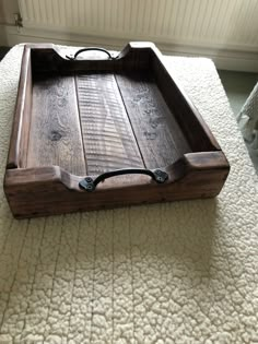 a wooden tray sitting on top of a white bed covered in carpeted flooring